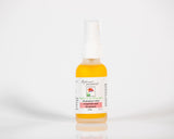 A 1 oz spray bottle of Rebecca's Journey All Purpose Mole fragrance, featuring a white label with red and green accents, filled with a yellow-orange liquid, set against a clean white background.